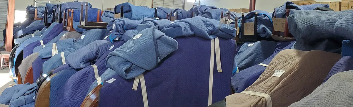 Rows of blanket-wrapped pianos in storage